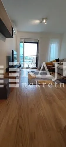 Living room with a sofa, TV, and access to the terrace.