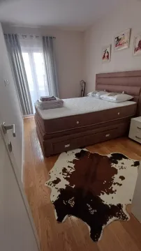 Bedroom with a double bed, wooden flooring, and balcony doors. - image 4