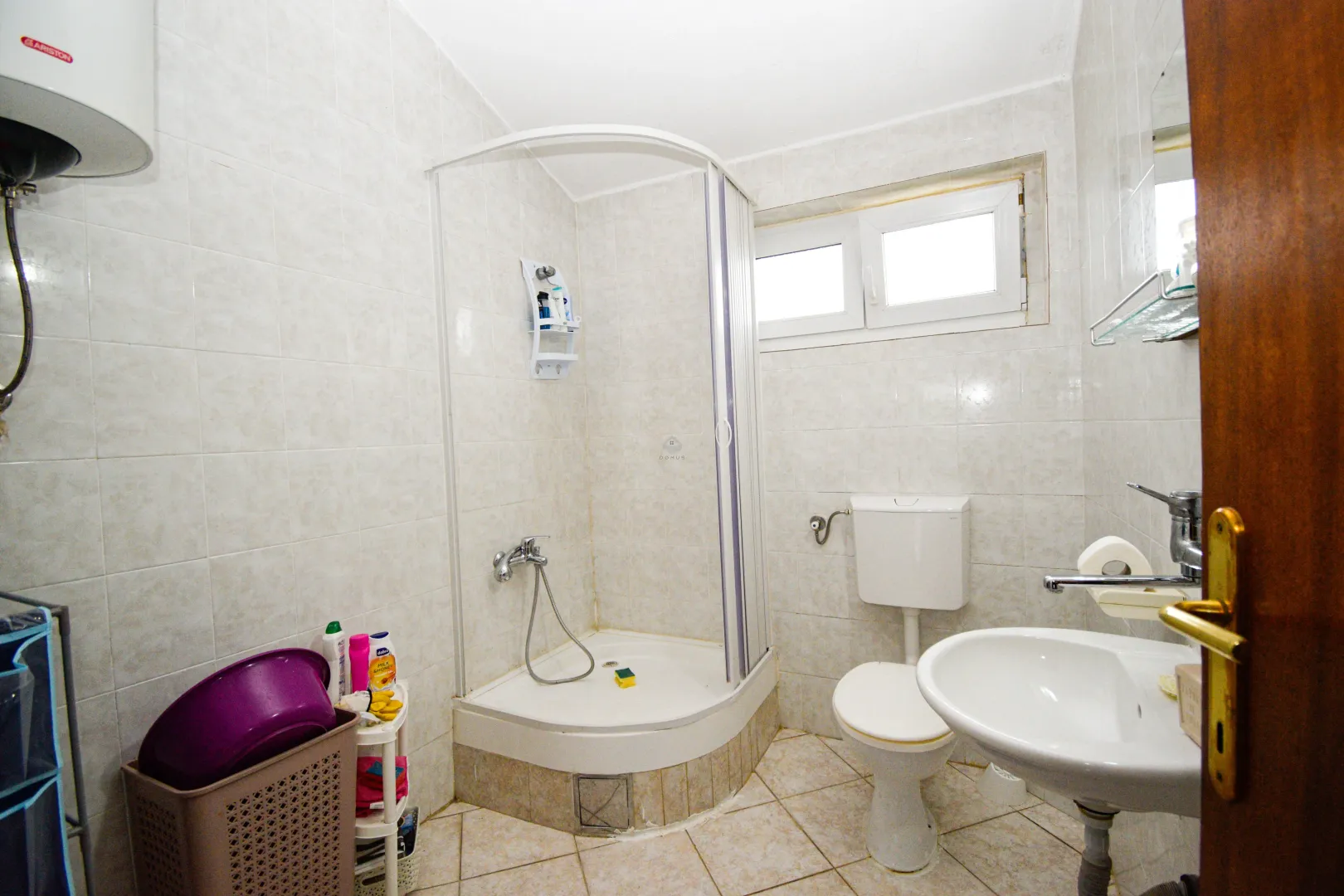 Bathroom equipped with a shower cabin, sink, and toilet.