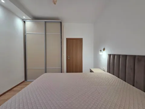 Furnished bedroom with a double bed, wardrobe, and wooden door. - image 8