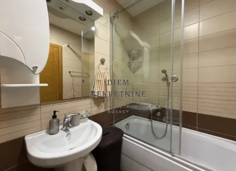 Furnished bathroom with a bathtub, sink, and mirror. - image 10