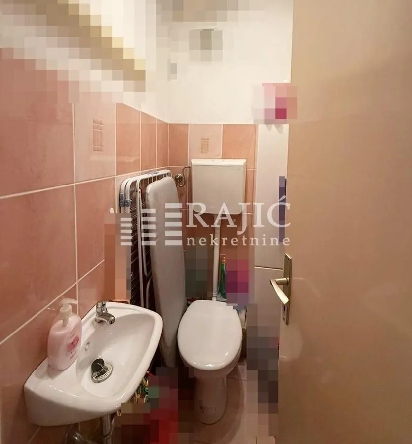 Smaller bathroom with a sink and toilet.