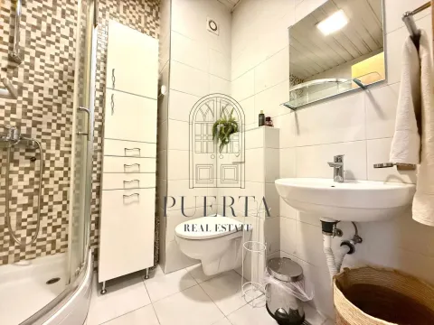 Smaller bathroom with a shower cabin, washbasin, and white cabinetry. - image 11