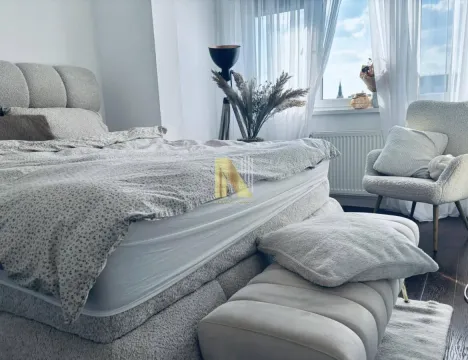 Svetla spavaća soba sa velikim krevetom, foteljom i prozorom prekrivenim zavesama. - image 6