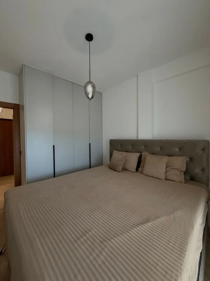 Modern bedroom with a double bed and fitted wardrobe.