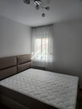 Spavaća soba sa bračnim krevetom i prozorom sa zavesama. - image 2