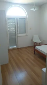 Jednostavna spavaća soba sa svijetlim laminatom i vratima za terasu. - image 11