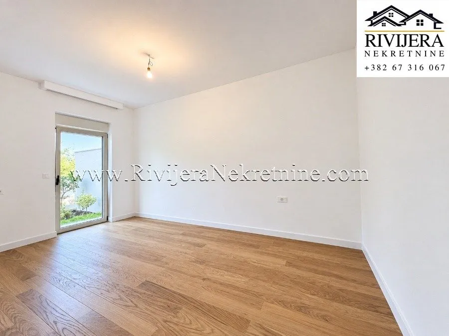 Empty bright room with wooden flooring and access to the yard.