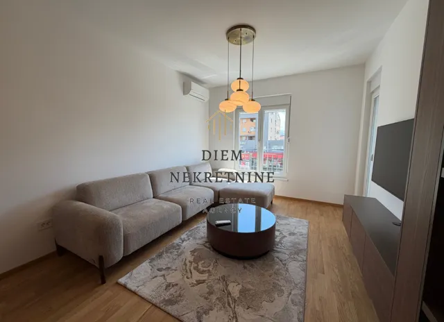 Living room with sofa, coffee table, and television.
