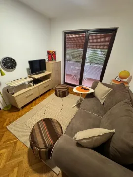 Dnevna soba sa garniturom, TV-om i izlazom na terasu. - image 5