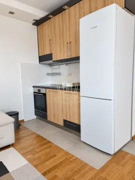 Kuhinja opremljena drvenim elementima, belim frižiderom i ugradnom rernom. - image 7