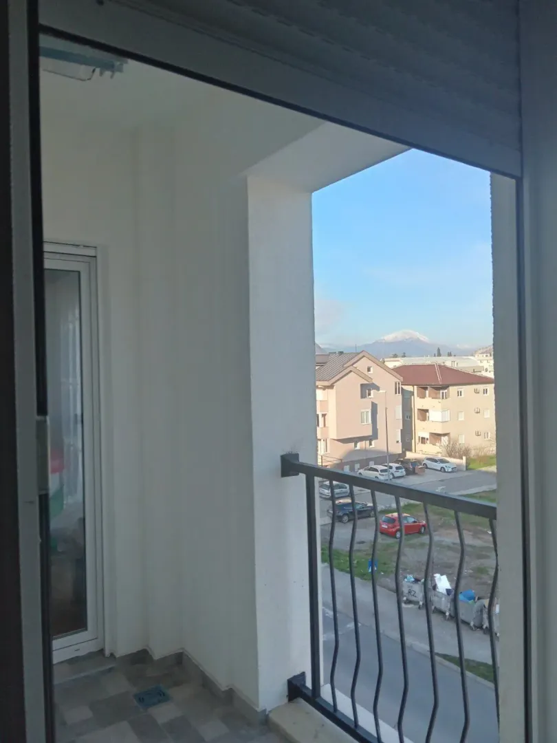 Pogled sa balkona na naselje i planinu.