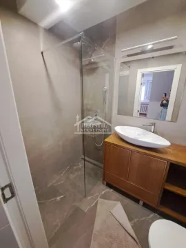 Moderno kupatilo sa tuš kabinom i drvenim ormarićem sa umivaonikom. - image 10