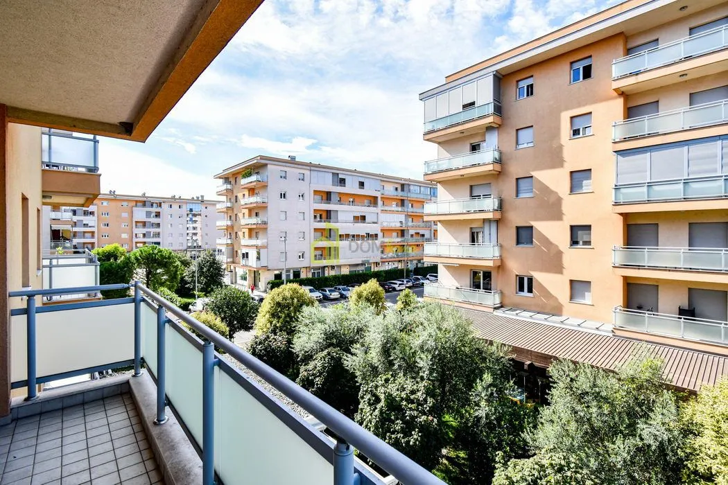 View from the balcony overlooking surrounding residential buildings and greenery.
