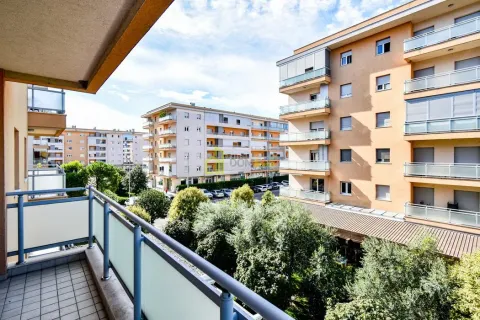 View from the balcony overlooking surrounding residential buildings and greenery. - image 25