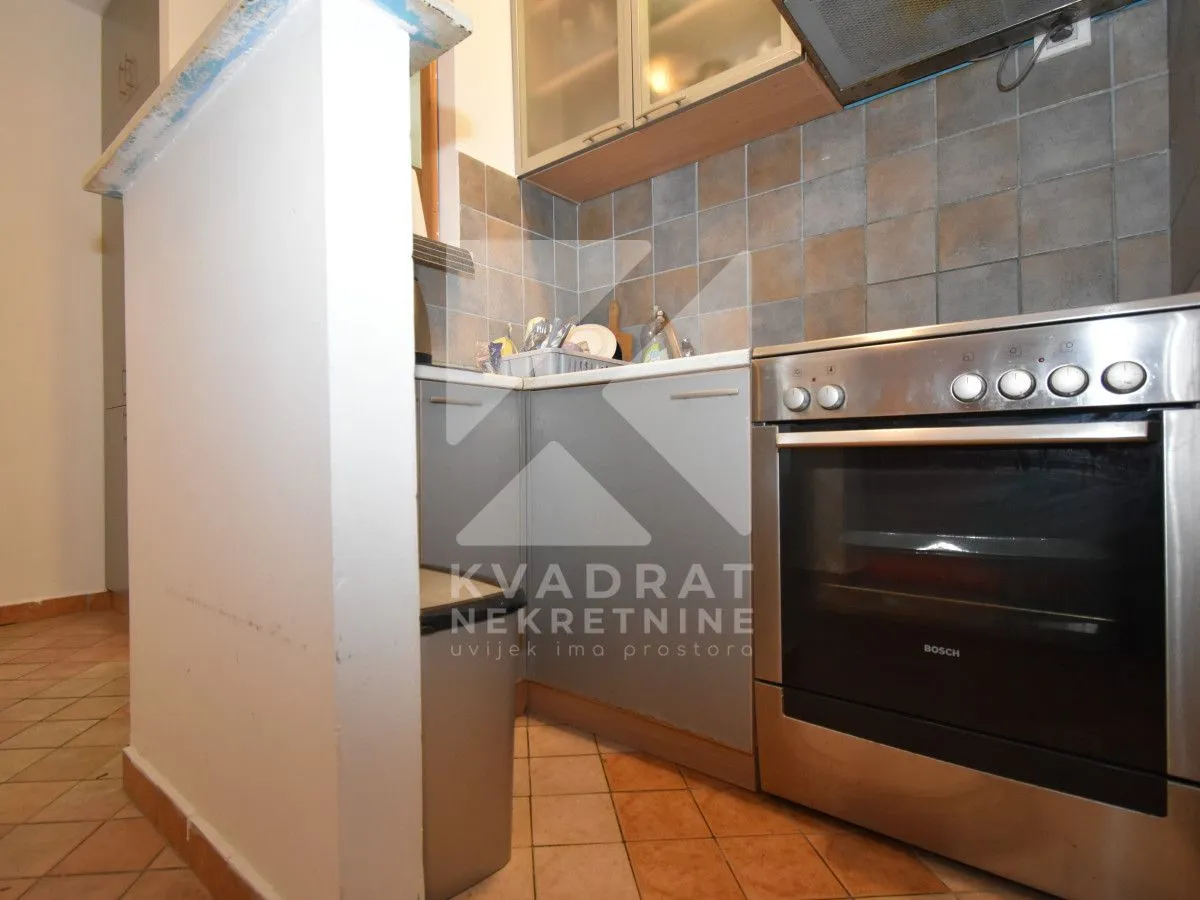 Smaller kitchen with a stove and cabinets.