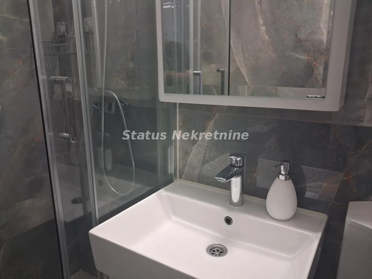 Moderno kupatilo sa umivaonikom i tuš kabinom.