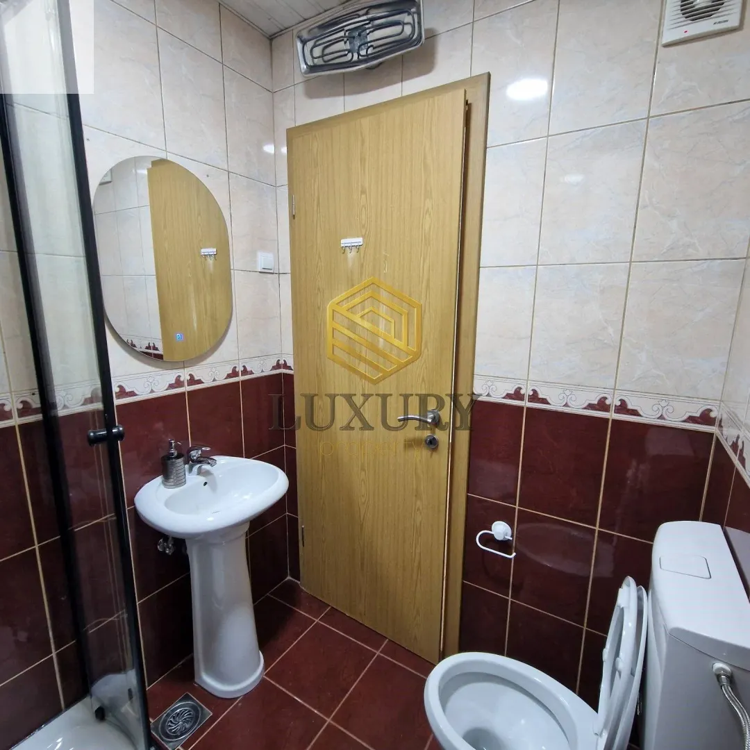 Smaller bathroom with a sink, toilet, and shower cabin.