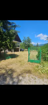 Dvorište sa zelenom ogradom i kućom u pozadini. - image 6