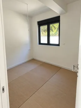 Prazna soba sa bijelim zidovima i zaštitnim papirom na podu. - image 4