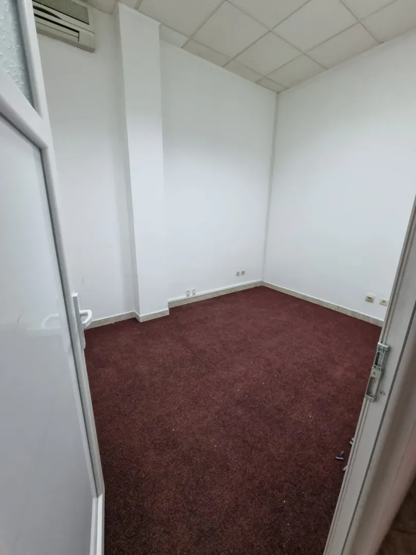 An empty room with red carpeting and white walls.