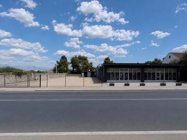 Street view of the commercial building and fenced plot.
