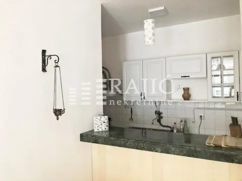 View of the kitchen with a breakfast bar and white cabinetry. - image 2