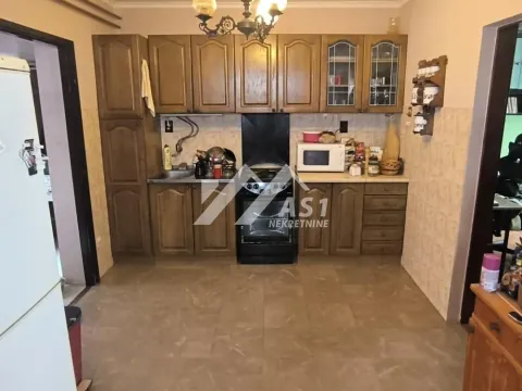 Older kitchen with wooden cabinets and a stove. - image 3