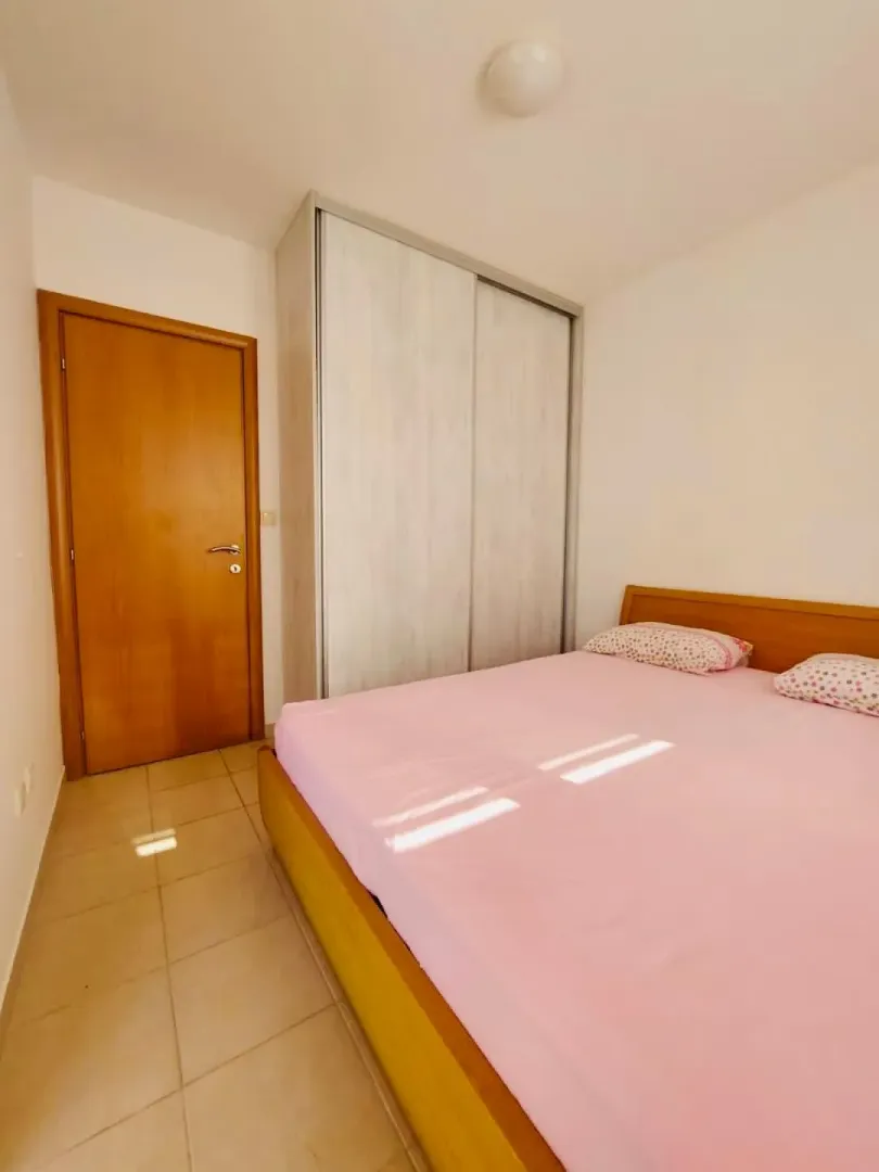 Bedroom with a double bed, wardrobe, and wooden door.