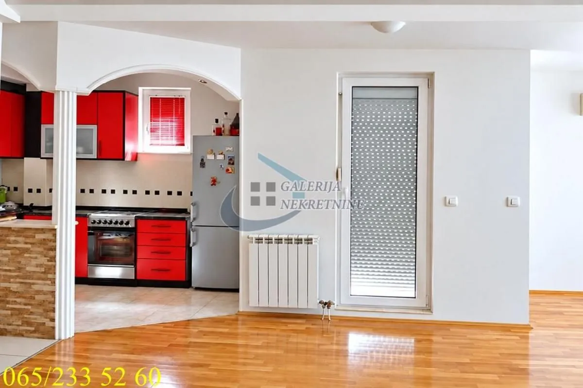 Dnevna soba sa pogledom na kuhinju i izlazom na terasu.