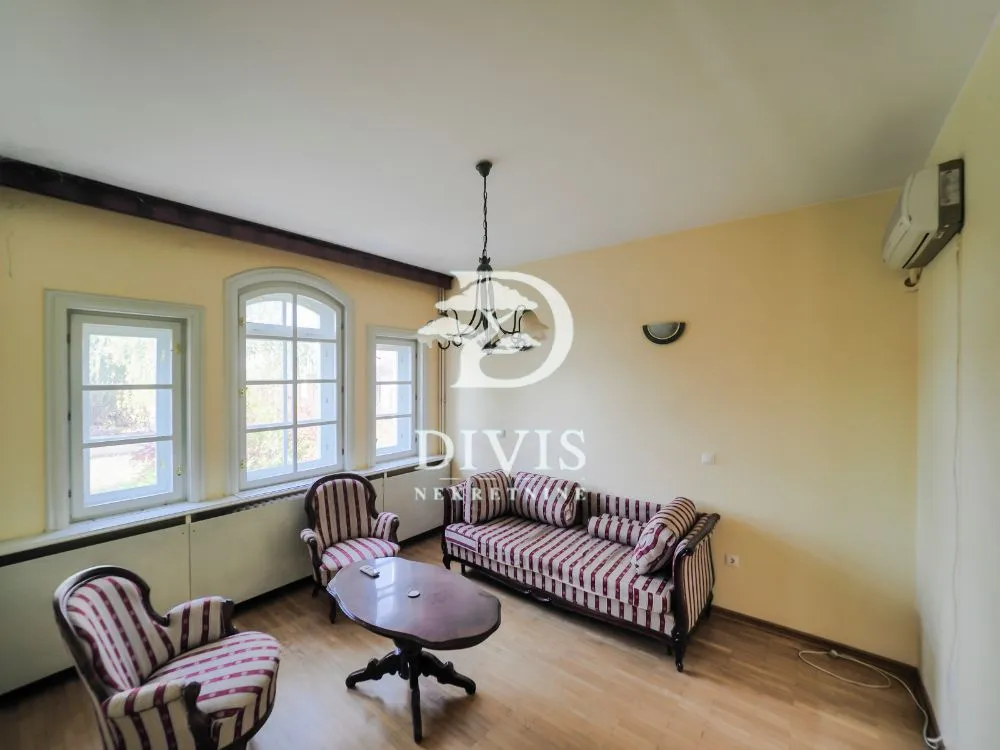 Living room with seating furniture and spacious windows.