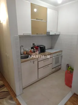 Small kitchen with white and brown cabinets and built-in oven. - image 3