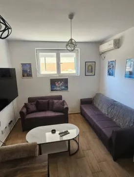 Dnevna soba sa garniturom za sedenje, stočićem i TV-om. - image 2