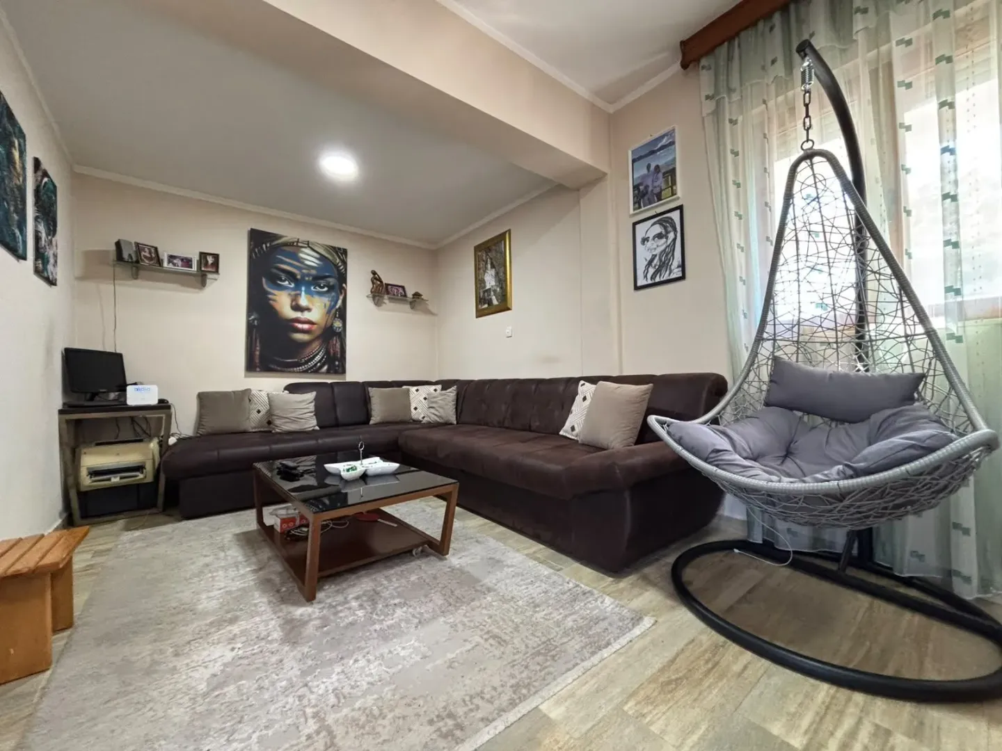 Living room with a sectional sofa, coffee table, and a hanging chair.