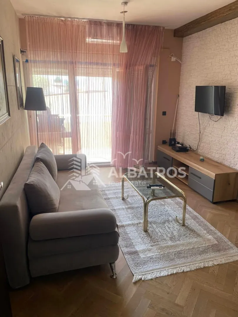 Living room with sofa, TV and access to the terrace.