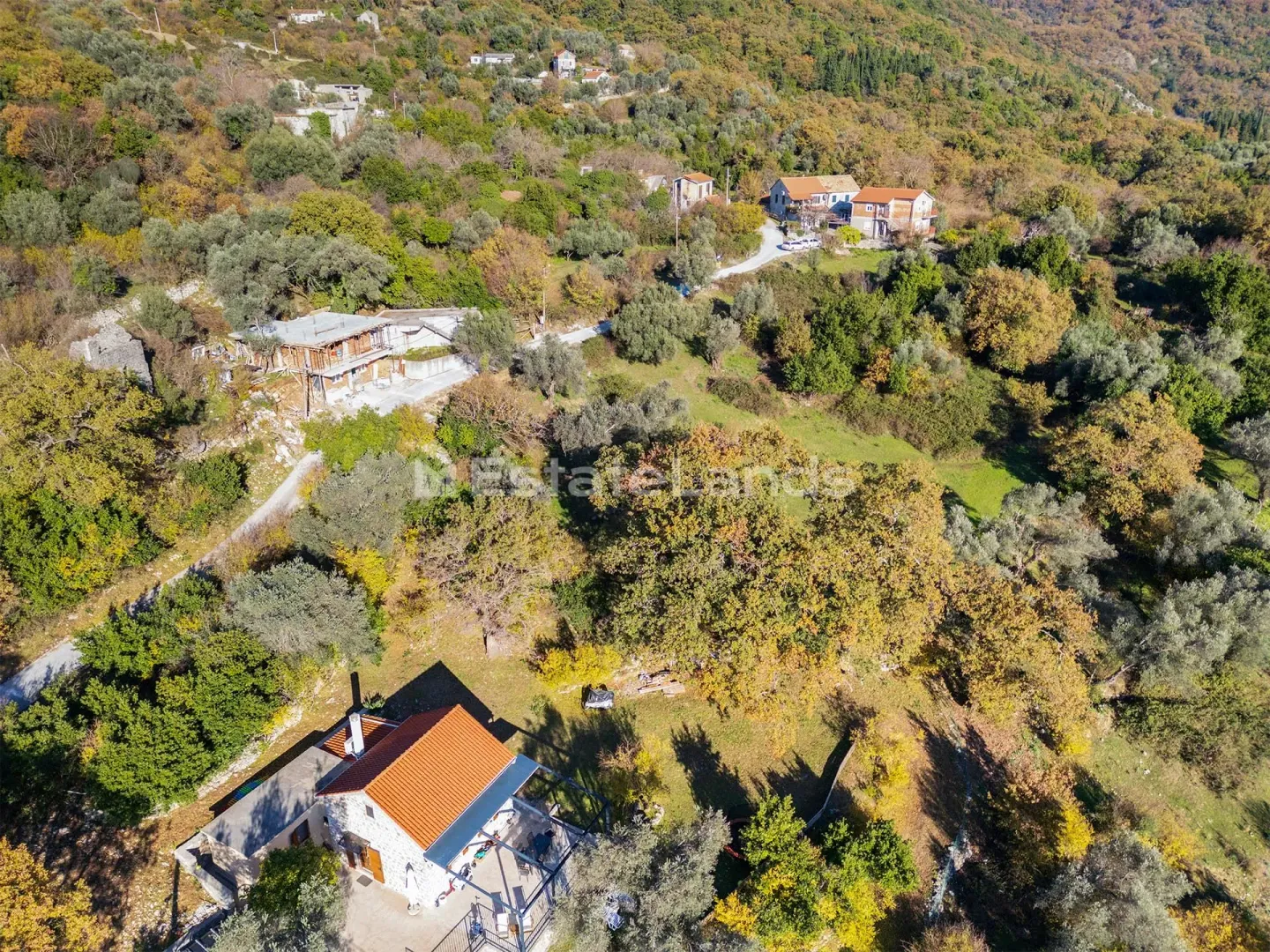 Pogled iz vazduha na seosko imanje sa kućom i okolnim zelenilom.
