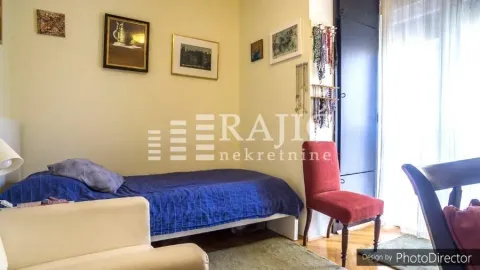 Dnevna soba sa krevetom, foteljom i umetničkim slikama na zidu. - image 11