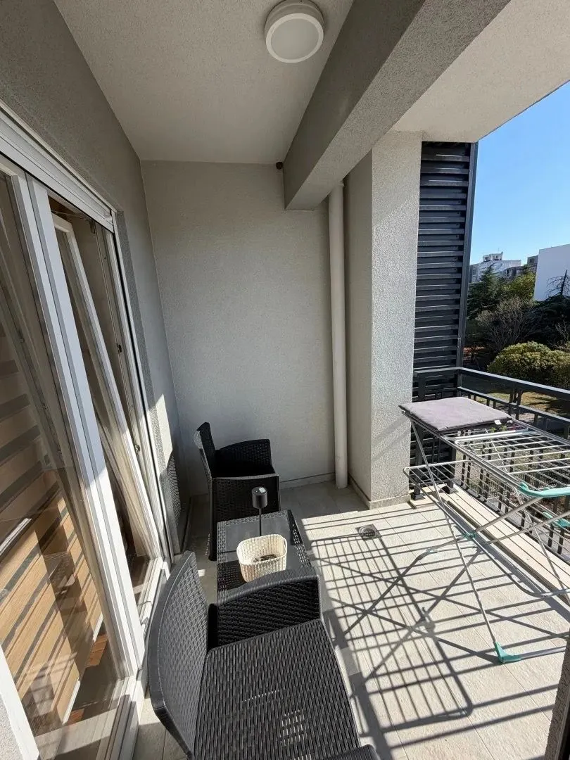 Unfurnished balcony with seating set and drying rack.