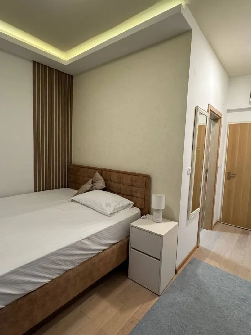 Furnished bedroom with a double bed and a nightstand.