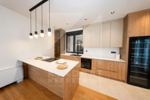 Modern kitchen with an island, built-in appliances, and a dining area. - image 20