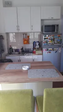 Manja kuhinja sa belim elementima i trpezarijskim stolom. - image 12
