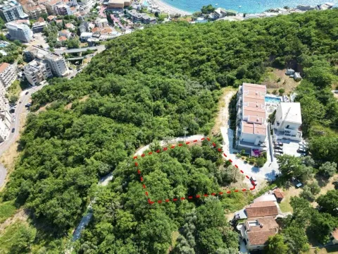 Zračni snimak urbanizovanog placa okruženog zelenilom i objektima u blizini mora. - image 2