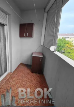 Glazed balcony with ceramic floor tiles and small furniture units. - image 11