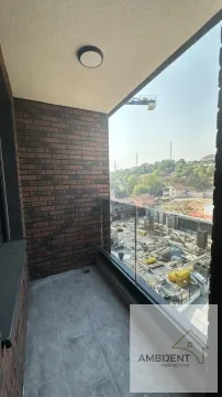 Natkriveni balkon sa staklenom ogradom i pogledom na okolinu. - image 20