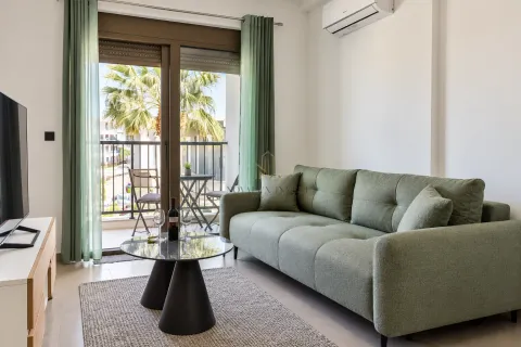 Living room with a green sofa, coffee table, and access to the terrace. - image 2