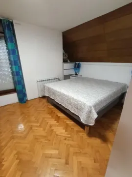 Spavaća soba sa bračnim krevetom i parketom na podu. - image 27
