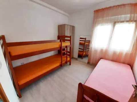 Spavaća soba sa krevetima na sprat i jednim zasebnim krevetom. - image 4