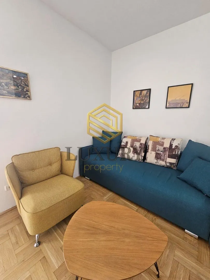 Living room with a blue sofa, yellow armchair and wooden coffee table.