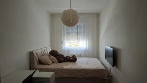 Manja spavaća soba sa bračnim krevetom, televizorom i prozorom sa zavesama. - image 6