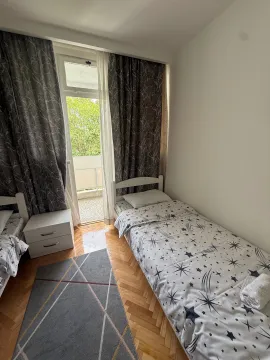 Bedroom with two single beds, parquet flooring, and access to a terrace. - image 20